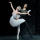 A male ballet dancer dressed in black doing a romantic pose with a female ballet dancer in a white tutu.